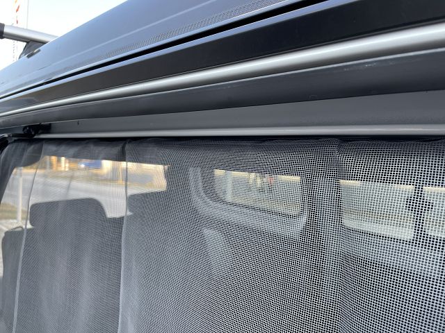 Dachkante von Dethleffs Globevan und Befestigtem Moskitonetz an der Öffnung der Seitentür