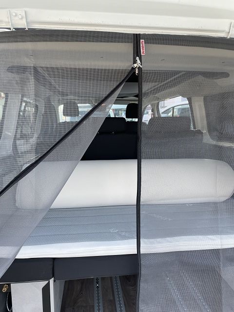 Dethleffs Globevan mit offener Heckklappe und befestigtem Moskitonetz / offener Reisverschluss vom Moskitonetz